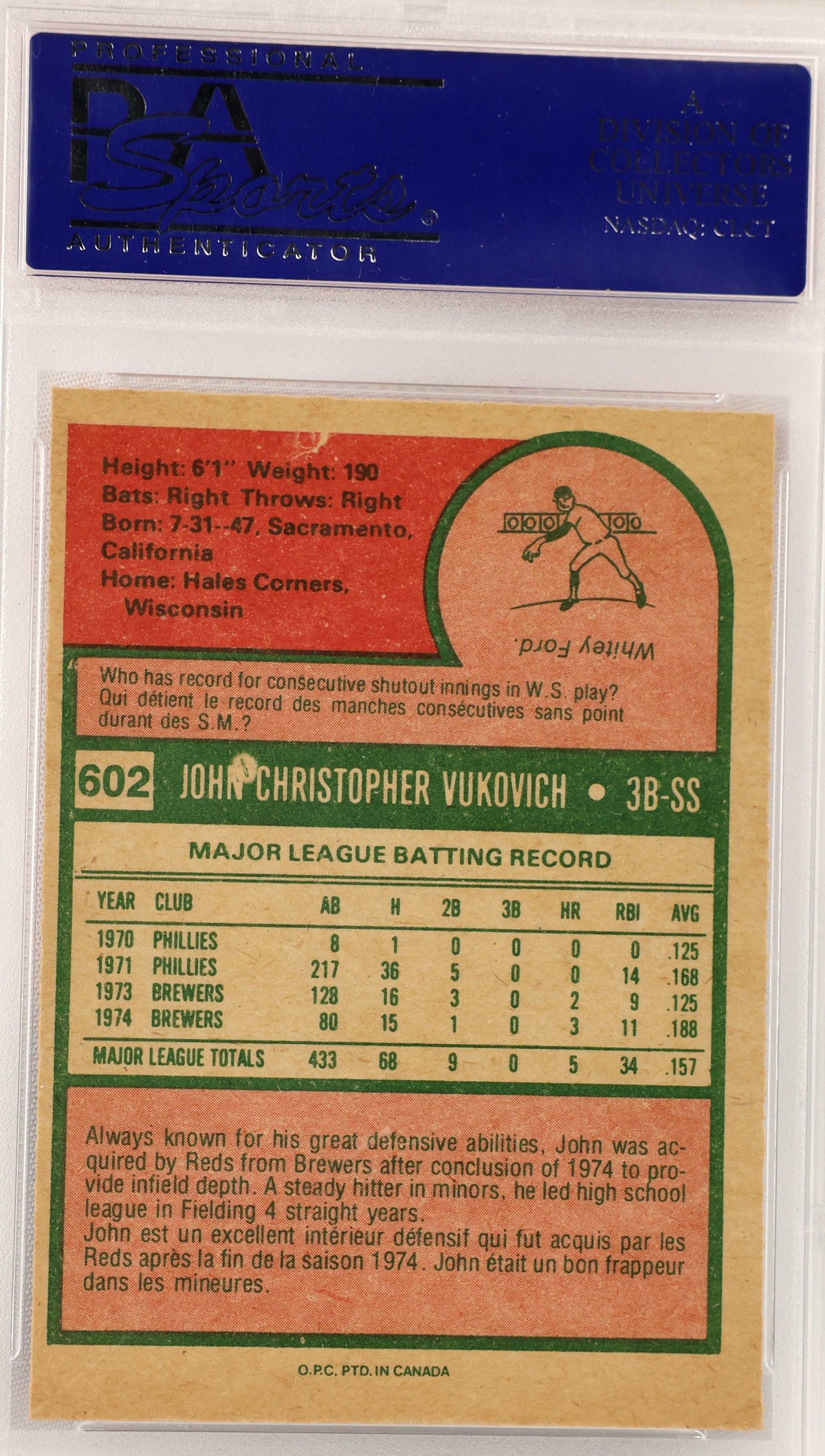 A vintage 1974 OTC baseball card for John Christopher Vukovich, graded and encapsulated by PSA as a PSA 8. The card features a tan background with red, green, and black text and graphics.