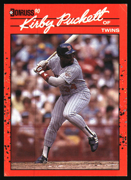 A vintage baseball trading card featuring Kirby Puckett of the Minnesota Twins in a batting stance. The card has a bold red border with black speckles and white script text reading 'Kirby Puckett OF TWINS' at the top, with the 'DONRUSS 90' logo in the upper left.