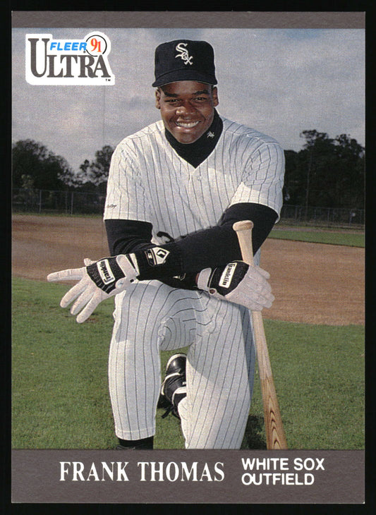 A vintage baseball trading card featuring Frank Thomas of the Chicago White Sox. The card shows Thomas kneeling on a baseball field wearing a white pinstripe uniform, black undershirt, and a black cap with the White Sox logo.