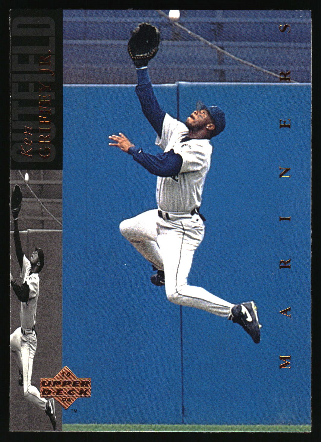 A vintage baseball trading card featuring Ken Griffel Jr. in a Seattle Mariners uniform, captured mid-air while reaching for a ball against a blue outfield wall.
