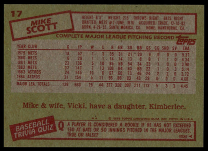 The back of a vintage 1985 Topps baseball trading card featuring Mike Scott, showing his player stats, biographical details, and trivia questions in red and black text on a tan background.
