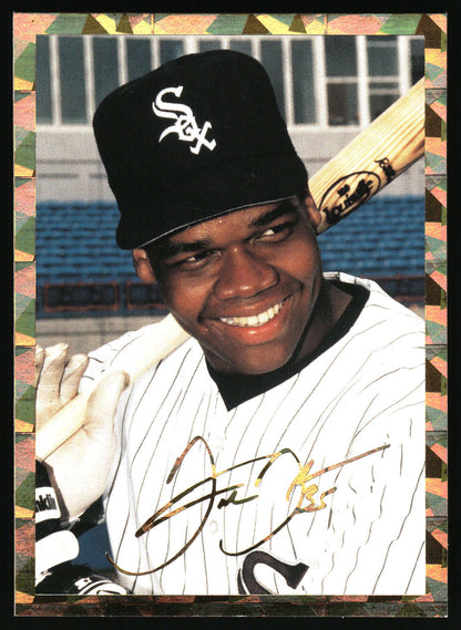 An autographed baseball trading card featuring a Frank Thomas in a black Chicago White Sox cap and white pinstripe uniform, holding a bat, with a decorative border around the card.