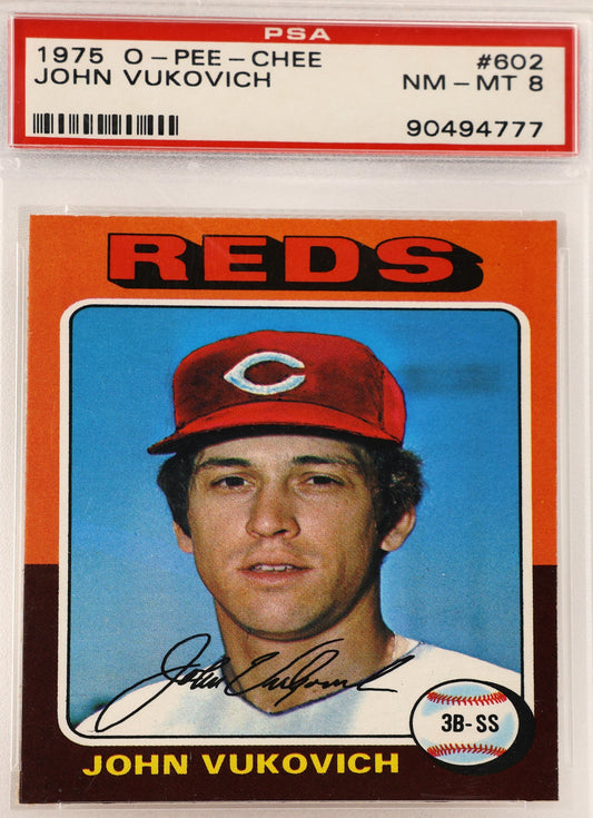 A PSA graded 1975 Cincinnati Reds John Vukovich baseball card, sealed in a clear plastic protective holder. The card features a portrait of Vukovich in a red cap against a blue background, with an orange border and a red PSA label at the top.