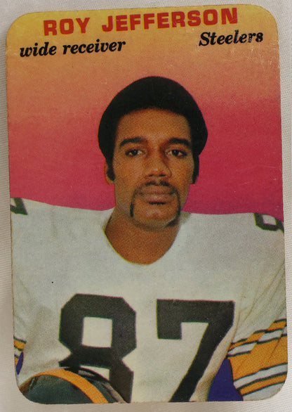 A vintage Roy Jefferson football trading card, number 87 for the Steelers, housed in a clear protective plastic sleeve. The card features a portrait of Roy Jefferson in a white jersey with the number 87, set against a pink and orange gradient background.