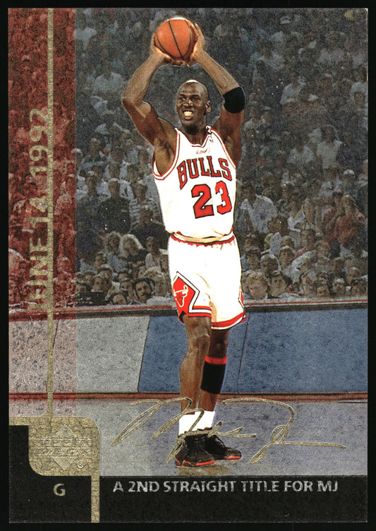 A basketball trading card featuring Michael Jordan in a white Chicago Bulls uniform with the number 23, holding a basketball above his head on a court with a crowd in the background. The card has a textured border on the left reading 'June 14 1992' and text at the bottom reading 'A 2ND STRAIGHT TITLE FOR MJ'.