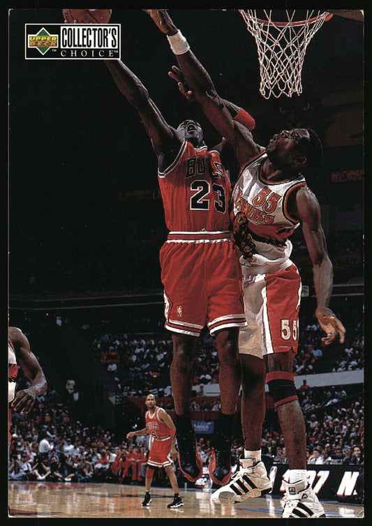 A basketball trading card featuring Michael Jordan in a red Chicago Bulls jersey jumping for a basketball, with another player in a white Bulls jersey defending him. The card has an 'Upper Deck Collector's Choice' logo in the top left corner.